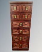 A narrow eight drawer chest with metal drop handles in a mahogany finish