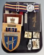A tray of military wooden plaques together with a Seiko wristwatch, coins, military badges and belt.