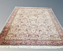 A machine made carpet of Persian Kirman design, on cream ground, 376cm by 273cm.