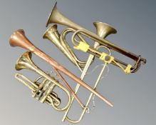 A collection of musical instruments including a brass cornet, brass bugle, three horns.