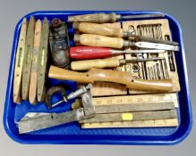 A tray containing folding wooden rulers, chisels, woodworking tools, brass mounted levels,