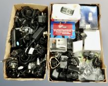 Two boxes containing vintage mobile phones, transformers and assorted leads.