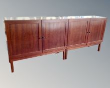 A pair of Danish double door cabinets on raised legs in a mahogany finish