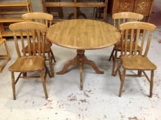 A circular kitchen pedestal table together with four chairs.