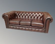 A Chesterfield brown buttoned leather three seater settee.
