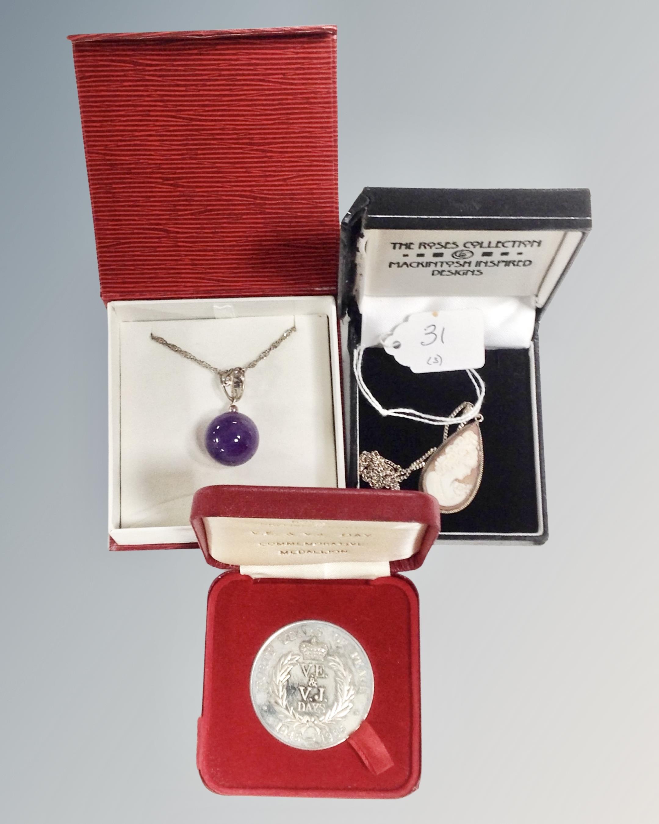 A silver shell cameo pendant on silver chain together with a purple glass pendant on silver chain,
