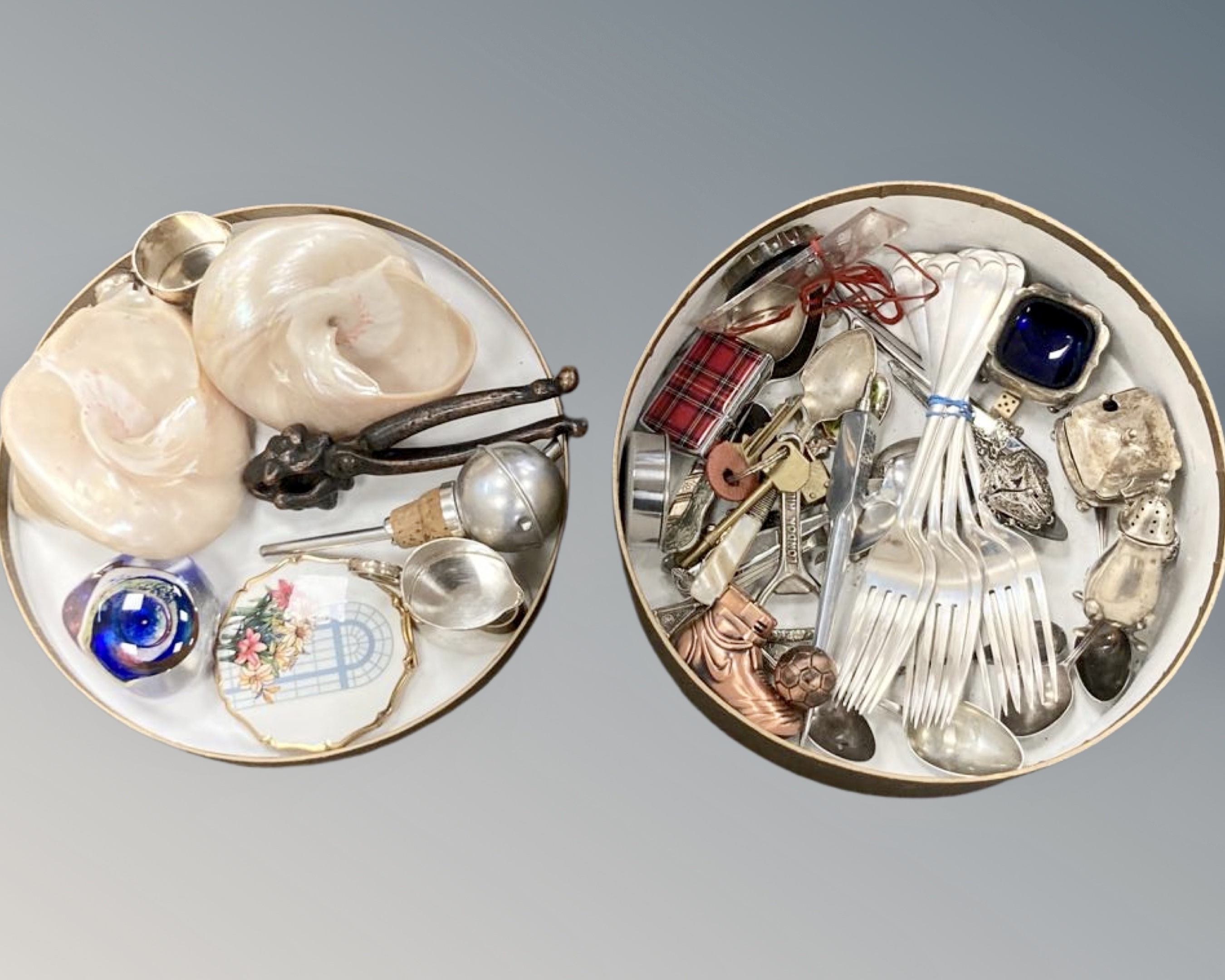 A collection of trinkets, shells, lighters, cutlery,