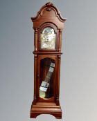 A contemporary longcase clock with moon phase dial, pendulum and weights.