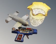 A vintage two-tone glass oil lamp shade together with a model aeroplane and tin plate rocket gun