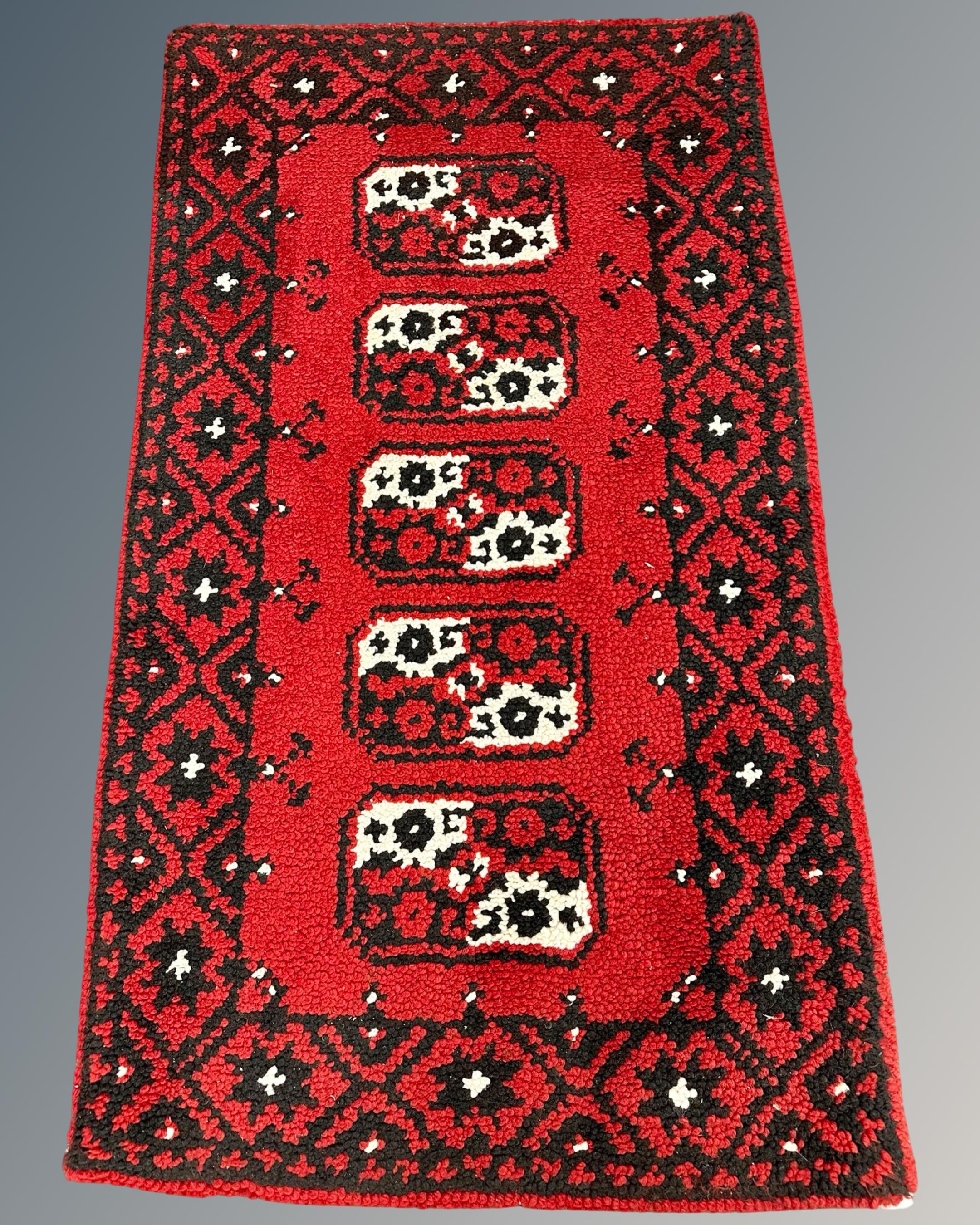 An eastern woollen rug, 73cm by 130cm.