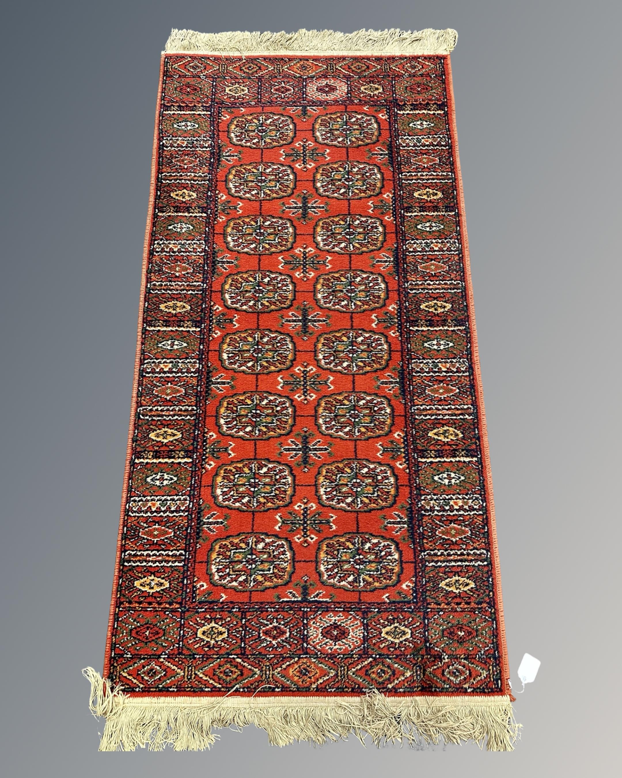 A machined Bokhara design rug, 69cm by 138cm.