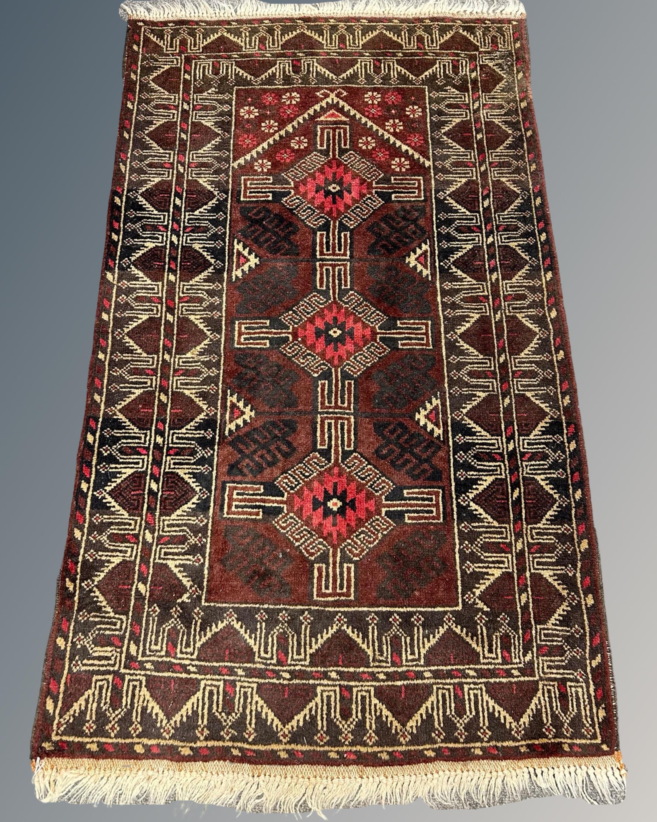 An Afghan rug of geometric design, 88cm by 148cm.