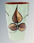 A studio pottery vase decorated with leaves.