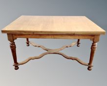 A French walnut rectangular pull out dining table with understretcher.