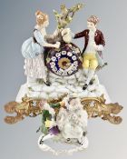 A continental ceramic and gilt metal figural mantel clock together with a further figure group.