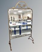 A brass framed Art Nouveau mirrored fire screen.