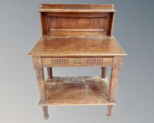 An early 20th century oak two tier serving table fitted a drawer
