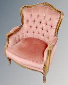 A carved beech framed Italian style armchair upholstered in a pink dralon.