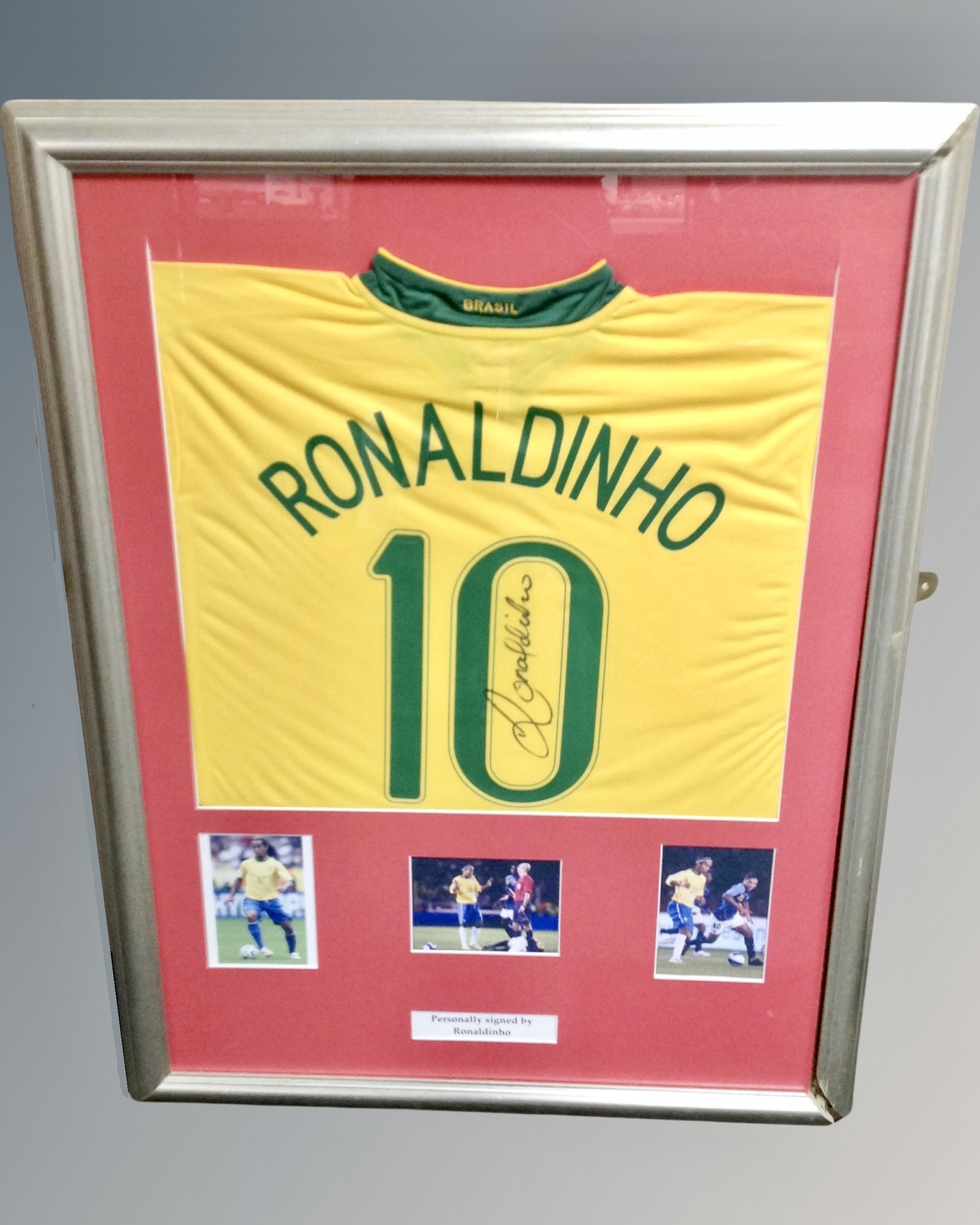 A Ronaldinho signed football shirt in frame with photographic montage, certificate verso.