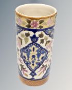 An early 20th century cylindrical pottery vase decorated with flowers.