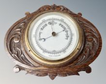 An Edwardian barometer in carved oak frame