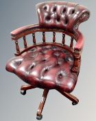 A Chesterfield oxblood leather captain's swivel armchair.