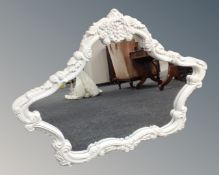 A contemporary French style shaped overmantel mirror in white frame.