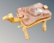 A camel stool with leather saddle.