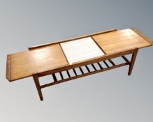 A mid-20th century teak pull out coffee table with melamine inset panel.