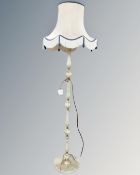 A gilt and onyx standard lamp with shade.