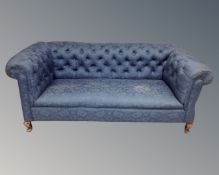 A 19th century Chesterfield drop end settee upholstered in a blue floral fabric.