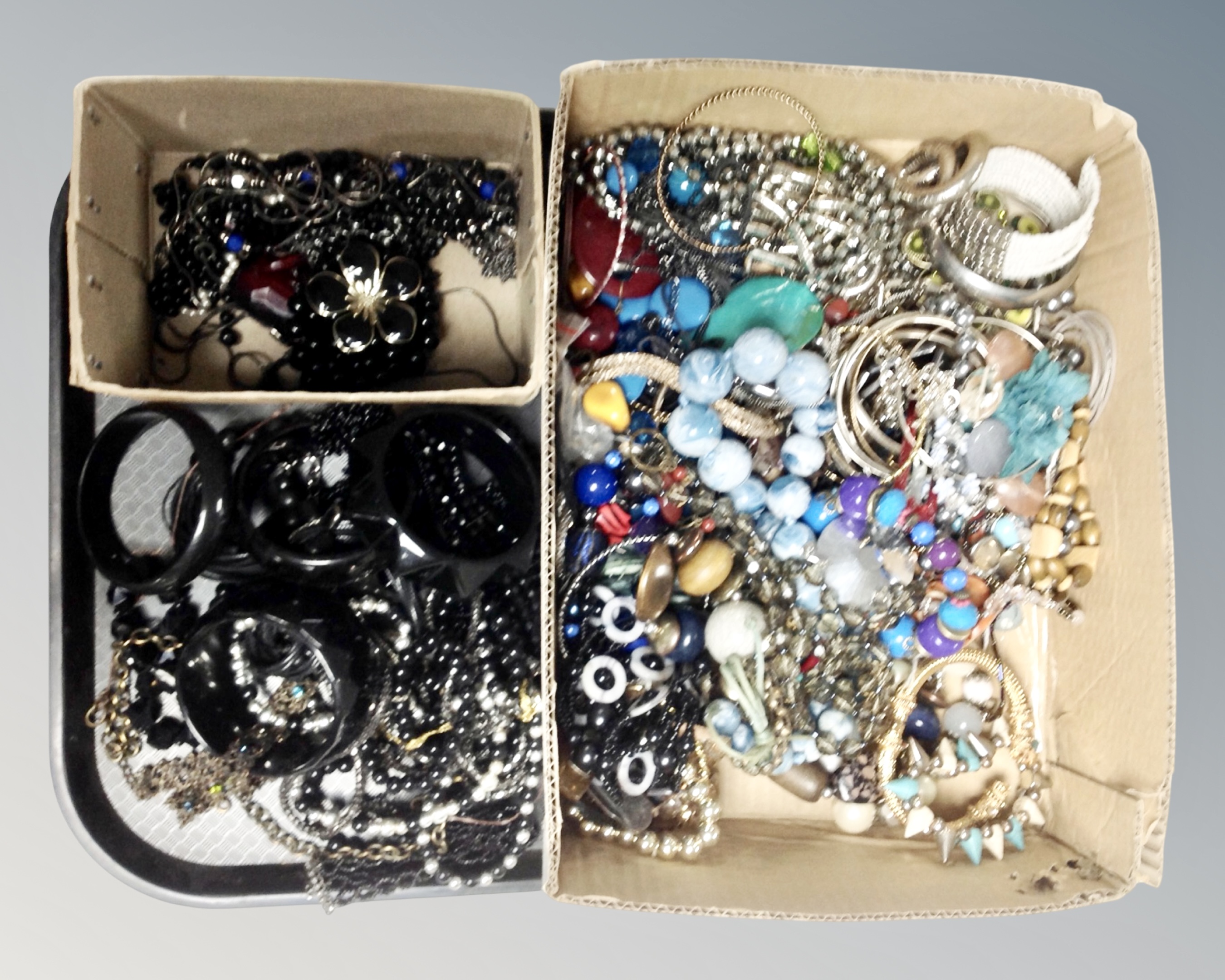 A box of costume jewellery together with a small box of mourning jewellery including French jet.