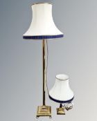A brass floor lamp on paw feet with shade,