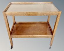 A 20th century oak and plate glass topped two tier trolley.