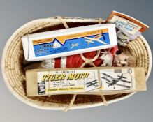 A basket containing porcelain headed collector's dolls together with two airplane modelling kits,