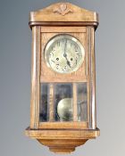 An Edwardian oak cased eight day wall clock with silvered dial