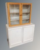A painted pine door wall cabinet together with a further painted double door cupboard.