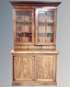 A Victorian mahogany double door glazed bookcase fitted with three drawers and sliding doors below.