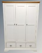 A contemporary painted oak topped triple door wardrobe fitted with three drawers together with a