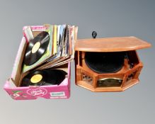 A retro style music centre together with a box containing assorted vinyl records.