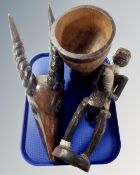 A tray containing African carvings including figure, animal head and bowl.