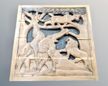 A carved hardwood frieze panel depicting African wildlife,