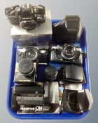 A tray containing Olympus cameras and accessories including three OM-10 cameras, lenses, winders,