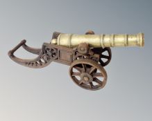 A brass miniature cannon on cast iron stand.