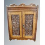 A 19th century carved oak double door smoker's cabinet.