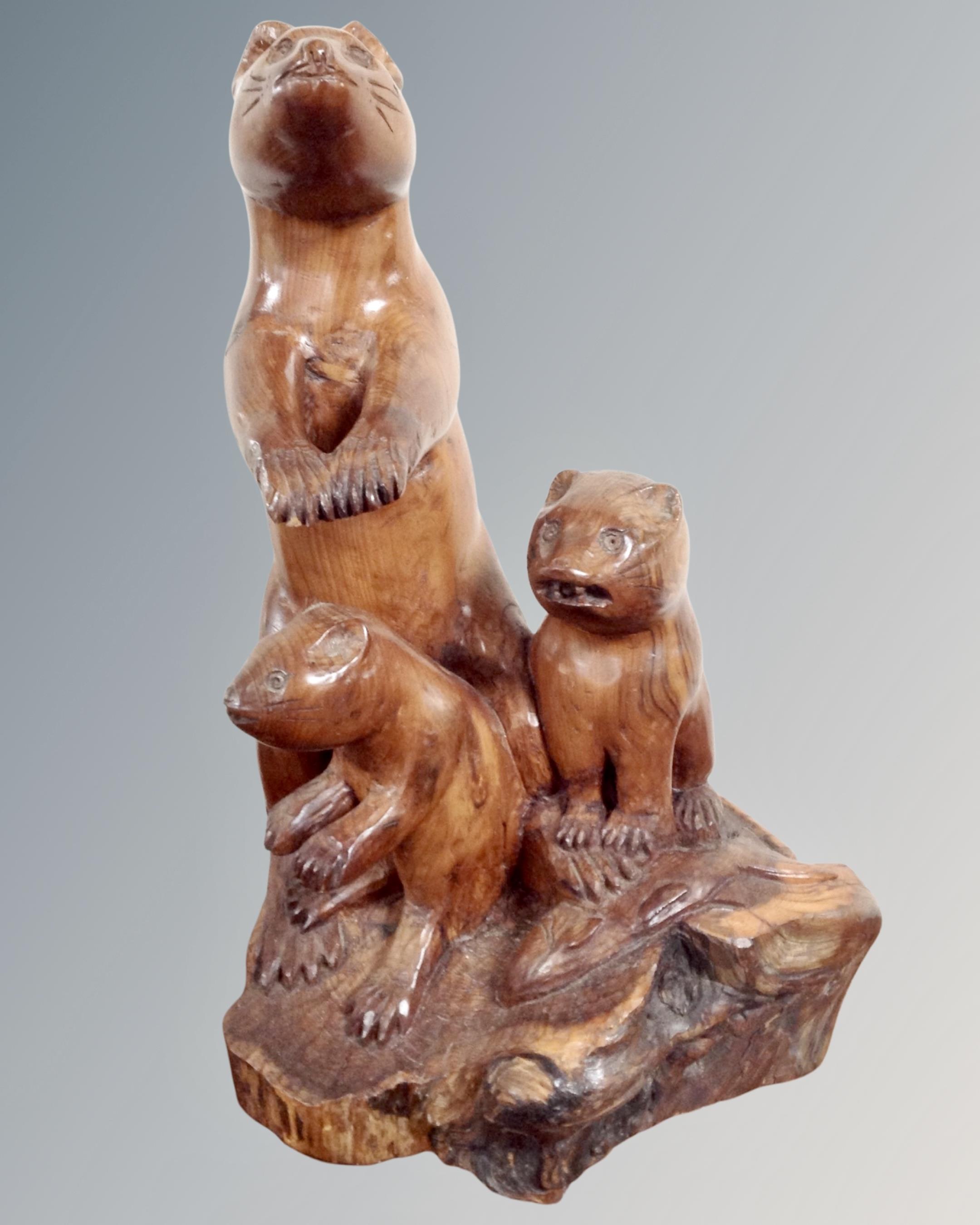 A carved wooden figure of a meerkat family.