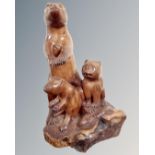 A carved wooden figure of a meerkat family.