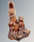 A carved wooden figure of a meerkat family.