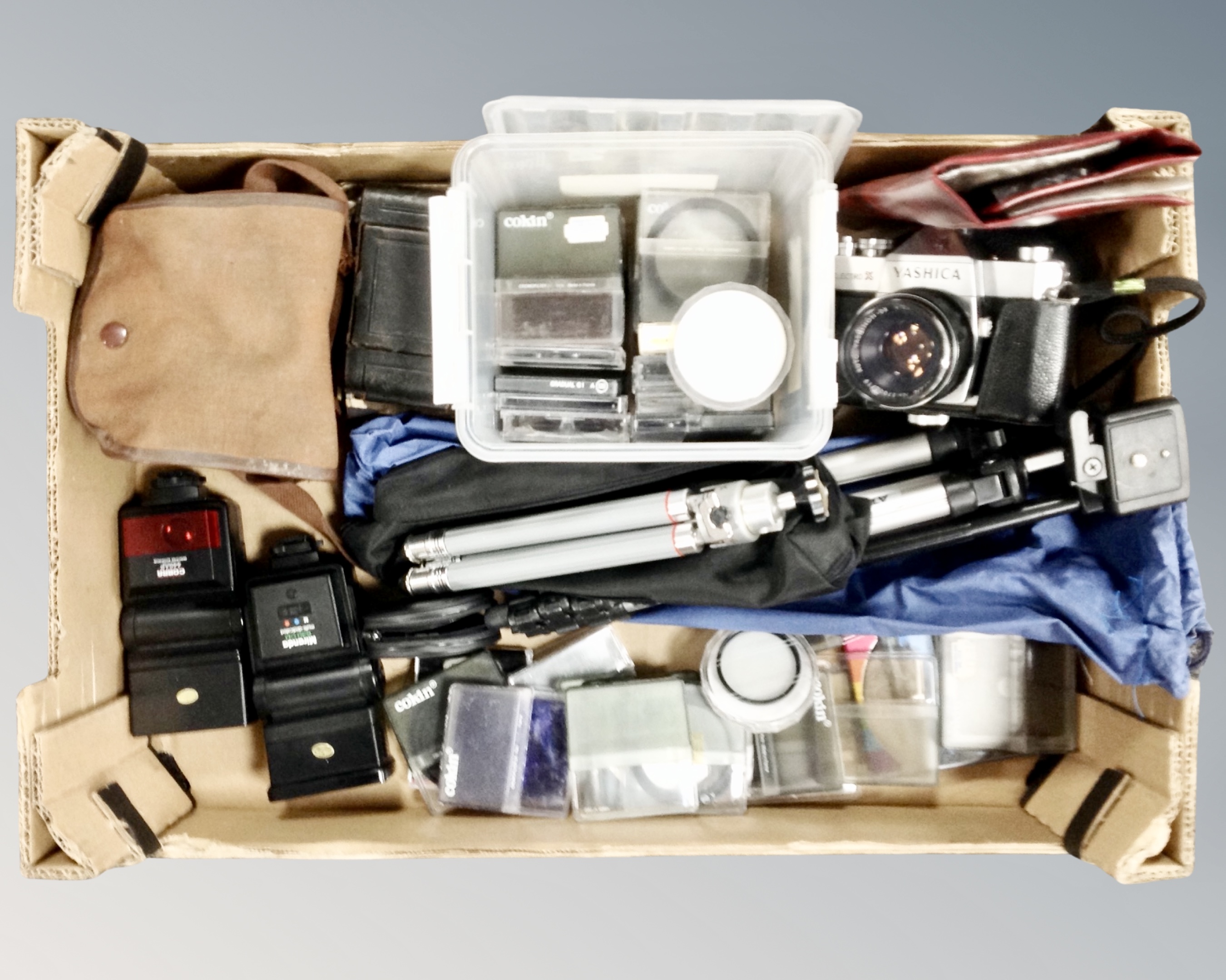 A box containing a Yashica TL Electro-X camera together with further vintage cameras, filters,