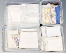 Four plastic storage boxes with lids containing vintage and later linen.